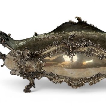 Louis XV style table planter in silver (800) decorated with flowers, resting on four lion claw feet.