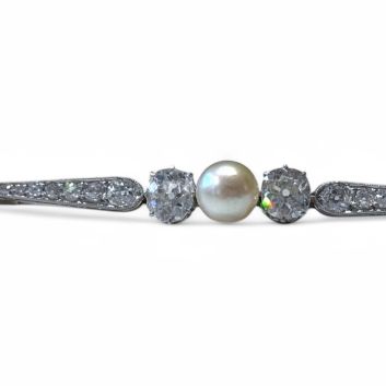 Broche barrette en or gris 18k (750e) et platine, centrée d'une perle de culture d'environ 7 mm épaulée de diamants