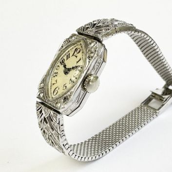 Montre art nouveau en or blanc (750) Boitier orné de petits brillants et ciselé sur les côtés, bracelet décoré de palmettes